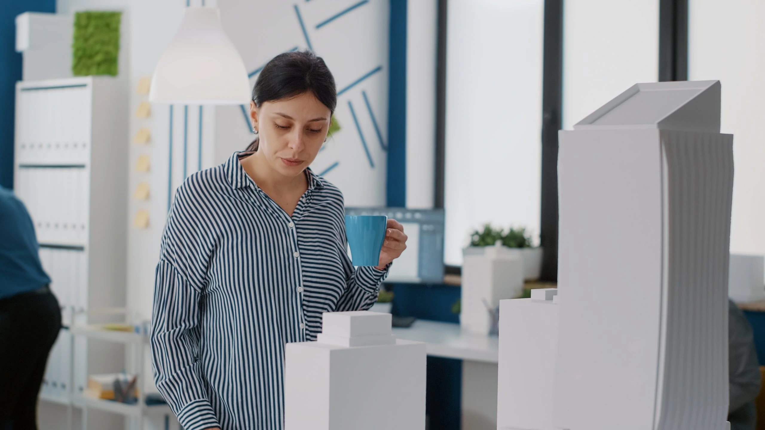 Woman drinking coffee in modern office